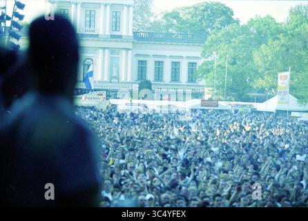 Poupée libération, Haarlem, pays-Bas, 04-05-2000 Whizgle News, Dutch Desk, pays-Bas, 1950-2000 Une foule nombreuse se rassemble devant un grand bâtiment, les mains levées dans l'excitation, alors qu'une performance se déroule sur scène. Les tentes et les bannières indiquent une atmosphère de festival animée, entourée d'arbres et d'une toile de fond historique. Banque D'Images