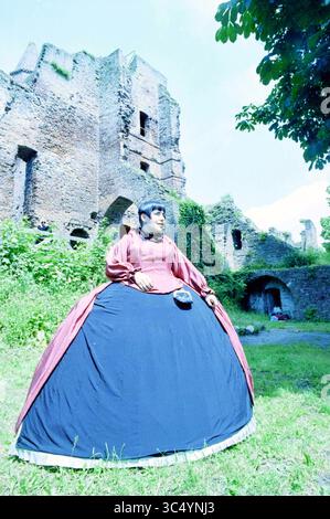 Vêtu d'une robe de l'époque (XIIIe siècle) des ruines de Brederode., Santpoort, Velserenderlaan, 17-06-1995 Whizgle News, Dutch Desk, pays-Bas, 1950-2000 Une figure vêtue d'une robe élégante et volumineuse se dresse gracieusement devant les vestiges d'une structure historique en pierre, entourée d'une végétation luxuriante. Le tissu doux et fluide de la robe contraste avec les textures robustes des ruines, créant une harmonie visuelle saisissante entre le passé et le présent. Banque D'Images