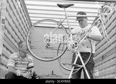 Mosquito Round, SP'woude, Spaarnwoude, 14-08-1994 Whizgle News, Dutch Desk, pays-Bas, 1950-2000 deux hommes travaillent ensemble pour assembler un vélo. Un homme se concentre sur l'ajustement du vélo tandis que l'autre regarde attentivement de côté, offrant probablement de l'aide ou des conseils. Les outils et l'équipement peuvent être vus à proximité, indiquant un environnement pratique d'entretien ou d'assemblage de bicyclettes. Banque D'Images
