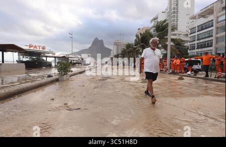 29 juillet 2025, Rio de Janeiro, Rio de Janeiro, Brésil : un homme marche dans une avenue Delfim Moreira remplie de sable, alors que des équipes de nettoyage municipales de Rio de Janeiro de Comlurb ont été envoyées pour aider à nettoyer les suites d'une puissante tempête hivernale qui a envoyé des vagues de l'océan déferler sur la plage lors d'un rare événement d'onde de tempête, inondant la promenade Leblon et l'avenue Delfim Moreira. La vague violente a causé d'importants dommages à plusieurs kiosques en bord de mer et dispersé des débris sur la côte normalement animée. (Crédit image : © Bob Karp/ZUMA Press Wire) USAGE ÉDITORIAL SEULEMENT ! Non destiné à UN USAGE commercial ! Banque D'Images