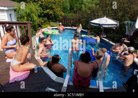 Les membres de la famille célèbrent et restent au frais dans la piscine des parents après le mariage des filles. Downers Grove Illinois il États-Unis Banque D'Images