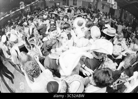 Carnaval à Noordwijkerhout, Carnaval, 22-02-1971 Whizgle News, Dutch Desk, pays-Bas, 1950-2000 Une foule animée danse ensemble lors d'un événement festif, orné d'une gamme de costumes et de chapeaux élaborés. L'atmosphère est remplie d'énergie alors que les gens se mêlent, rient et célèbrent dans des quartiers rapprochés, créant un sentiment de joyeuse camaraderie. Banque D'Images