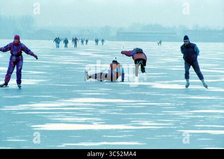 Tour de patinage sur glace Haarlem, patiné le long, Haarlem, pays-Bas, 07-01-1997 Whizgle News, Dutch Desk, pays-Bas, 1950-2000 Une scène animée sur une surface gelée où les patineurs glissent et profitent de la journée d'hiver, certains mettant en valeur leurs compétences tandis que d'autres font un culbutement. Le paysage givré renforce l'atmosphère joyeuse que les gens de tous âges s'engagent dans le plaisir du patinage sur glace. Banque D'Images