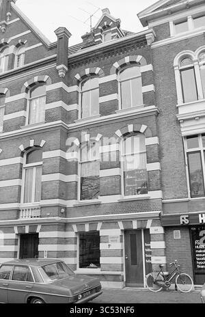 Bâtiments et fissures, Schotersingel 117, Huizen Haarlem, Haarlem, Schotersingel, pays-Bas, 27-01-1977 Whizgle News, Dutch Desk, pays-Bas, 1950-2000 Un bâtiment vintage avec des briques rayées saisissantes, de grandes fenêtres et des éléments décoratifs. Le rez-de-chaussée affiche quelques portes et fenêtres, tandis qu'une voiture garée et un vélo sont positionnés à proximité, ajoutant à la scène urbaine. Banque D'Images
