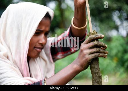 19 décembre 2019, Guwahati, Assam, Inde : une femme fabrique des bâtons de feu de bouse de vache et les met à sécher au soleil. (Crédit image : © David Talukdar/ZUMA Wire/ZUMAPRESS.com) Banque D'Images