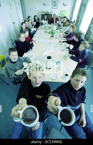 Prêté action, Hillegom, 12-04-2001 Whizgle News, Dutch Desk, pays-Bas, 1950-2000 Un grand groupe de jeunes s'est réuni autour d'une longue table, chacun tenant une tasse, profitant probablement d'un moment de fête ou de camaraderie. La salle est remplie de sourires et d'un sentiment de communauté car ils partagent une boisson chaude ensemble. Banque D'Images