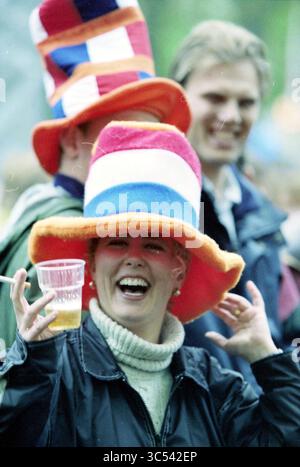 Poupée libération Gil Scott-Heron Haarlem, Haarlem, pays-Bas, 04-05-1998 Whizgle News, Dutch Desk, pays-Bas, 1950-2000 Une femme joyeuse portant un grand chapeau coloré lève une tasse en plastique, souriant largement alors qu'elle aime un rassemblement festif. En arrière-plan, d'autres se joignent à la célébration, ajoutant à l'atmosphère animée. Banque D'Images