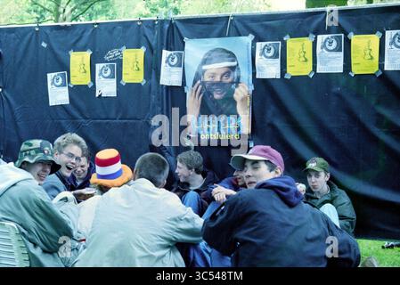 Poupée de libération diverse Haarlem, Haarlem, pays-Bas, 04-05-1998 Whizgle News, Dutch Desk, pays-Bas, 1950-2000 Un groupe de jeunes se réunit autour d'une table, discutant et profitant de la compagnie des autres. Derrière eux, un mur est orné d'affiches et de dépliants, dont un représentant une personne portant un masque. L’atmosphère apparaît animée et informelle, suggérant un événement social ou communautaire. Banque D'Images