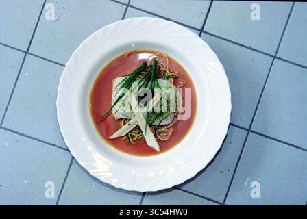 Signez au restaurant de Hong Kong, 13-04-1999 Whizgle News, Dutch Desk, pays-Bas, 1950-2000 Un plat magnifiquement arrangé avec des nouilles délicates garnies d'un morceau de poisson tendre, garni de ciboulette fraîche et de légumes finement tranchés, le tout dans un bouillon savoureux. Banque D'Images