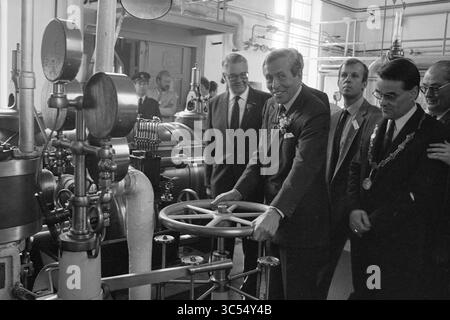 Ouverture de la station de pompage de vapeur à mi-chemin de Prince Claus, ouverture, ouvertures, mise en service, station de pompage de vapeur et station de pompage de vapeur, Halfweg, 10-06-1987 Whizgle News, Dutch Desk, pays-Bas, 1950-2000 Un groupe d'hommes habillés se réunit autour d'une grande machine industrielle, un homme souriant lorsqu'il interagit avec le panneau de commande, suggérant un moment de célébration ou de démonstration. L'atmosphère transmet un sentiment d'innovation et de progrès, avec diverses composantes mécaniques en vue. Banque D'Images