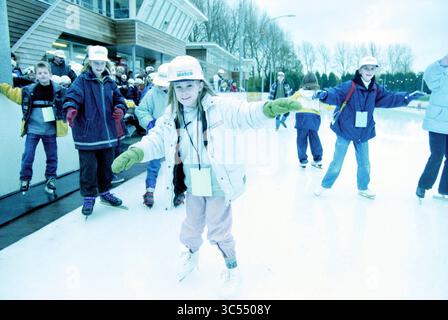 Patinage pour l'eau, Haarlem, pays-Bas, 08-11-1999 Whizgle News, Dutch Desk, pays-Bas, 1950-2000 Un groupe d'enfants profite d'une journée de patinage sur glace, portant des vêtements d'hiver et des chapeaux ludiques. Un enfant glisse gracieusement sur la glace, souriant tandis que les autres patinent en arrière-plan, créant une atmosphère animée et amusante. Banque D'Images