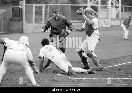 Baseball Nicols - Spartan, 29-06-1991 Whizgle News, Dutch Desk, pays-Bas, 1950-2000 Un moment tendu sur le terrain de baseball alors qu'un joueur glisse dans la plaque d'accueil, essayant d'éviter d'être étiqueté par le receveur, tandis que l'arbitre signale le jeu. L'atmosphère est chargée d'excitation alors que les coéquipiers regardent depuis les lignes de touche. Banque D'Images