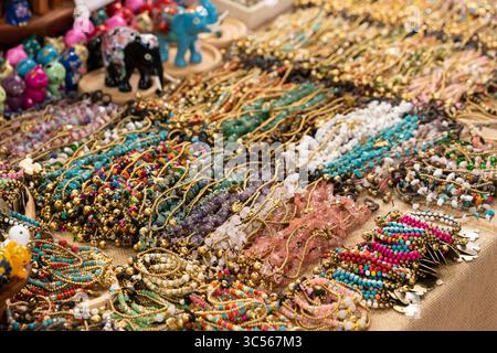 Affichage coloré de bracelets en perles faits à la main sur un marché ou un stand de souvenirs. Les bracelets sont fabriqués à partir d'une variété de matériaux. Banque D'Images