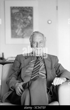 Ancien conseiller Geluk Hazepaterslaan, échevins, Haarlem, Hazepaterslaan, pays-Bas, 15-02-1988 Whizgle News, Dutch Desk, pays-Bas, 1950-2000 Un gentleman distingué est assis confortablement sur un canapé, vêtu d'un costume et d'une cravate sur mesure, avec un sourire chaleureux qui respire le charme. Derrière lui, une œuvre partiellement visible ajoute une touche de sophistication au décor. Banque D'Images