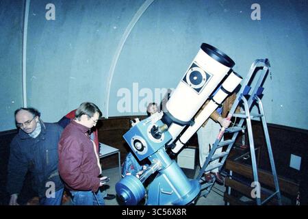 Observatoire des journées portes ouvertes (personnes regardant les étoiles depuis le dôme), Haarlem, pays-Bas, 13-02-1997 Whizgle News, Dutch Desk, pays-Bas, 1950-2000 Un groupe de personnes se réunit autour d'un grand télescope à l'intérieur d'un observatoire, une personne l'ajustant tandis que d'autres observent et engagent la conversation. Les murs incurvés de la structure du dôme créent un cadre impressionnant pour les activités d'observation des étoiles. Banque D'Images
