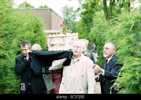 Funérailles Frans Verpoorten, Zwanenburg, Zwanenburg, 01-07-1997 Whizgle News, Dutch Desk, pays-Bas, 1950-2000 Un groupe d'individus solennels transporte un cercueil à travers un sentier verdoyant et luxuriant, entouré d'arbres. Leurs expressions reflètent un mélange de tristesse et de contemplation alors qu'ils se dirigent vers le lieu de sépulture. Banque D'Images