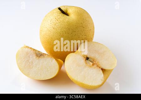 Une poire asiatique fraîche, avec un fruit entier, tranchée et une autre coupée en deux pour révéler sa chair et son noyau croustillants et blancs, isolés sur un fond blanc. Banque D'Images