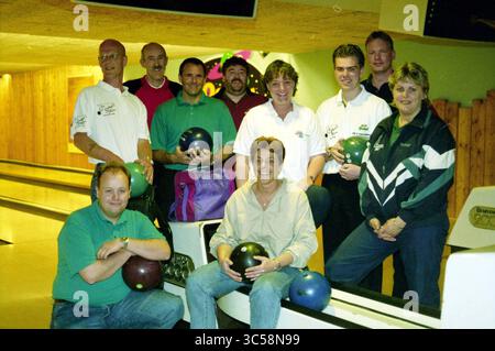 Compétition de bowling Claus Partyhouse, H'lem, Haarlem, Orionweg, pays-Bas, 09-05-1999 Whizgle News, Dutch Desk, pays-Bas, 1950-2000 Un groupe de dix personnes se tient ensemble dans une piste de bowling, chacune tenant une boule de bowling et souriant. Ils sont habillés dans une tenue décontractée, avec un mélange de polos et de vestes, mettant en valeur une atmosphère amicale et compétitive. L'arrière-plan présente des pistes de bowling et des lambris en bois, ajoutant à l'ambiance chaleureuse du lieu. Banque D'Images