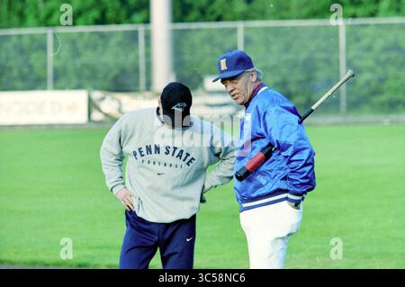Première formation de l'équipe néerlandaise de baseball, Haarlem, pays-Bas, 26-05-1998 Whizgle News, Dutch Desk, pays-Bas, 1950-2000 deux hommes discutent sur un terrain de baseball, l'un portant un sweat-shirt Penn State et l'autre une veste bleue tenant une batte de baseball. Le terrain herbeux s'étend en arrière-plan, suggérant un accent sur l'athlétisme et le travail d'équipe. Banque D'Images
