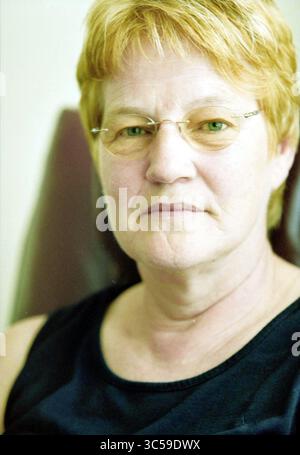 Tiny Peters, Rijsenhout, Rijsenhout, 03-06-2003 Whizgle News, Dutch Desk, pays-Bas, 1950-2000 Une femme aux cheveux courts et clairs et aux lunettes regarde directement le spectateur, affichant une expression calme et réfléchie. Elle porte un haut sans manches sombre et s'assoit confortablement, avec un fond neutre qui renforce sa présence. Banque D'Images