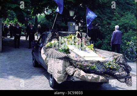 Funérailles Frans Verpoorten, Zwanenburg, Zwanenburg, 01-07-1997 Whizgle News, Dutch Desk, pays-Bas, 1950-2000 Un véhicule orné de fleurs et d'un filet décoratif transporte un cercueil, tandis que les personnes en deuil se rassemblent à proximité, vêtues d'une tenue sombre, reflétant une atmosphère solennelle. Banque D'Images