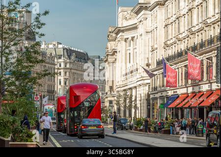 Bus à impériale rouges et piétons sur Oxford Street, au centre de Londres, lors d'une journée d'été lumineuse dans le quartier commerçant animé du Royaume-Uni. Banque D'Images