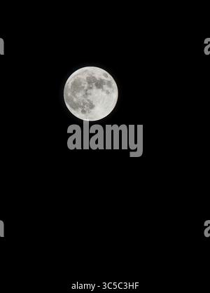Gros plan pointu de la pleine lune contre un ciel nocturne noir, montrant des cratères détaillés et des textures de surface. Banque D'Images