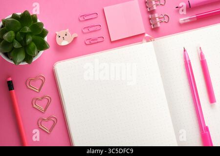 Fond de papeterie avec page de cahier vide et papeterie rose d'école et de bureau. À plat. Banque D'Images