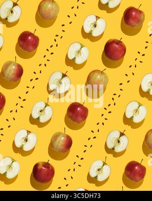 Motif de fruits sur fond jaune. Pommes entières, moitiés et graines dans l'ordre géométrique. Banque D'Images
