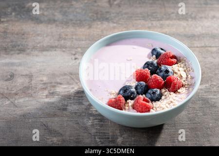 Bol à smoothie sain avec des baies sur une table en bois Banque D'Images