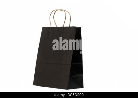 Un sac en papier noir avec des poignées en papier torsadées marron, placé sur un fond blanc Uni. Banque D'Images