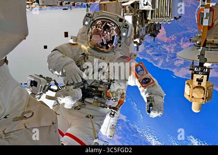 25 janvier 2020 - États-Unis - retour largué par la Terre en rotation, l'astronaute Col. Andrew Morgan fait une pause pour une séance photo pendant l'activité extravéhiculaire (EVA) #64 sur le site de travail du spectromètre magnétique Alpha de l'International Space Stationâ€™ le 25 janvier 2020. Col. Morgan et l'astronaute de l'armée de l'air italienne et de l'ESA Col. Luca Parmitano ont participé à cette quatrième et dernière EVA pour compléter les réparations de l'AMS, un détecteur de physique des particules de pointe. Les emblèmes affichés sur la liste de contrôle des manchettes de Col. Morgan sont le U.S. Army Space and missile Defense Command (en haut) et le U.S. Space Command (bott Banque D'Images