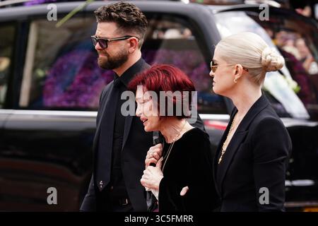 La famille d'Ozzy Osbourne (de gauche à droite) Jack Osbourne, Sharon Osbourne et Kelly Osbourne déposent des fleurs et regardent les messages et hommages floraux laissés sur le banc du pont Black Sabbath sur Broad Street à Birmingham en mémoire du chanteur Black Sabbath Ozzy Osbourne, alors que son corps est ramené dans sa ville natale pour une procession après sa mort la semaine dernière à l'âge de 76 ans. Date de la photo : mercredi 30 juillet 2025. Banque D'Images