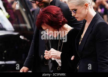 La famille d'Ozzy Osbourne (de gauche à droite) Jack Osbourne, Sharon Osbourne et Kelly Osbourne déposent des fleurs et regardent les messages et hommages floraux laissés sur le banc du pont Black Sabbath sur Broad Street à Birmingham en mémoire du chanteur Black Sabbath Ozzy Osbourne, alors que son corps est ramené dans sa ville natale pour une procession après sa mort la semaine dernière à l'âge de 76 ans. Date de la photo : mercredi 30 juillet 2025. Banque D'Images