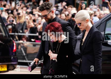 La famille d'Ozzy Osbourne (de gauche à droite) Jack Osbourne, Sharon Osbourne et Kelly Osbourne déposent des fleurs et regardent les messages et hommages floraux laissés sur le banc du pont Black Sabbath sur Broad Street à Birmingham en mémoire du chanteur Black Sabbath Ozzy Osbourne, alors que son corps est ramené dans sa ville natale pour une procession après sa mort la semaine dernière à l'âge de 76 ans. Date de la photo : mercredi 30 juillet 2025. Banque D'Images