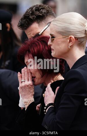 La famille d'Ozzy Osbourne (de gauche à droite) Jack Osbourne, Sharon Osbourne et Kelly Osbourne déposent des fleurs et regardent les messages et hommages floraux laissés sur le banc du pont Black Sabbath sur Broad Street à Birmingham en mémoire du chanteur Black Sabbath Ozzy Osbourne, alors que son corps est ramené dans sa ville natale pour une procession après sa mort la semaine dernière à l'âge de 76 ans. Date de la photo : mercredi 30 juillet 2025. Banque D'Images