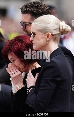 La famille d'Ozzy Osbourne (de gauche à droite) Jack Osbourne, Sharon Osbourne et Kelly Osbourne déposent des fleurs et regardent les messages et hommages floraux laissés sur le banc du pont Black Sabbath sur Broad Street à Birmingham en mémoire du chanteur Black Sabbath Ozzy Osbourne, alors que son corps est ramené dans sa ville natale pour une procession après sa mort la semaine dernière à l'âge de 76 ans. Date de la photo : mercredi 30 juillet 2025. Banque D'Images