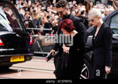 La famille d'Ozzy Osbourne (de gauche à droite) Jack Osbourne, Sharon Osbourne et Kelly Osbourne déposent des fleurs et regardent les messages et hommages floraux laissés sur le banc du pont Black Sabbath sur Broad Street à Birmingham en mémoire du chanteur Black Sabbath Ozzy Osbourne, alors que son corps est ramené dans sa ville natale pour une procession après sa mort la semaine dernière à l'âge de 76 ans. Date de la photo : mercredi 30 juillet 2025. Banque D'Images