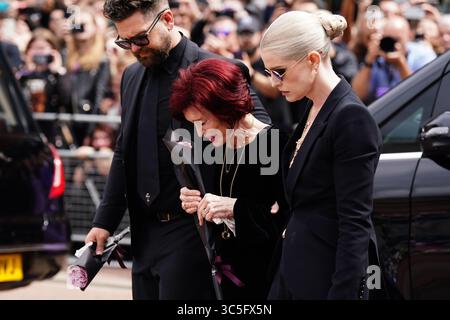 La famille d'Ozzy Osbourne (de gauche à droite) Jack Osbourne, Sharon Osbourne et Kelly Osbourne déposent des fleurs et regardent les messages et hommages floraux laissés sur le banc du pont Black Sabbath sur Broad Street à Birmingham en mémoire du chanteur Black Sabbath Ozzy Osbourne, alors que son corps est ramené dans sa ville natale pour une procession après sa mort la semaine dernière à l'âge de 76 ans. Date de la photo : mercredi 30 juillet 2025. Banque D'Images