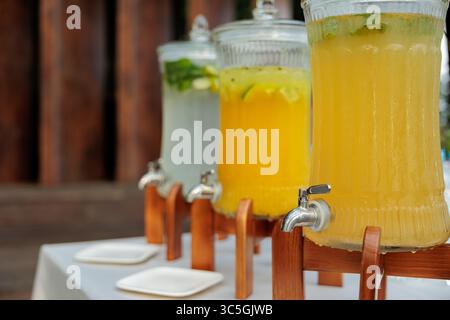 Banque en verre de limonade avec des agrumes tranchés sur une table de buffet. Fête estivale en plein air. Détox. limonade Banque D'Images