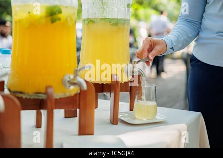 Banque en verre de limonade avec des agrumes tranchés sur une table de buffet. Fête estivale en plein air. Détox. limonade Banque D'Images