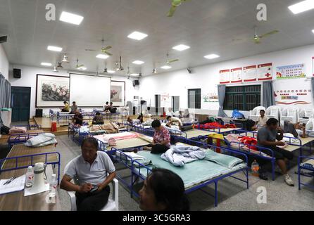 (250730) -- SHANGHAI, 30 juillet 2025 (Xinhua) -- des citoyens sont photographiés à l'intérieur d'un centre communautaire devenu site de relocalisation dans le district de Fengxian de Shanghai, dans l'est de la Chine, le 30 juillet 2025. Co-May, le huitième typhon de cette année, a touché terre pour la deuxième fois dans la municipalité de Shanghai dans l'est de la Chine mercredi après-midi après avoir touché terre dans la province du Zhejiang tôt mercredi matin, selon l'observatoire météorologique central de Shanghai. Le centre du typhon Co-May (niveau de tempête tropicale) a touché terre pour la deuxième fois sur la côte du district de Fengxian, Shanghai vers 16 h 40 à l'heure O. Banque D'Images