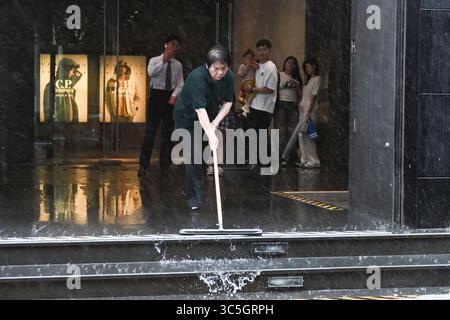 (250730) -- SHANGHAI, 30 juillet 2025 (Xinhua) -- Un membre du personnel expulse les eaux de crue à l'entrée d'une station de métro dans le district de Jing'an à Shanghai, dans l'est de la Chine, 30 juillet 2025. Co-May, le huitième typhon de cette année, a touché terre pour la deuxième fois dans la municipalité de Shanghai dans l'est de la Chine mercredi après-midi après avoir touché terre dans la province du Zhejiang tôt mercredi matin, selon l'observatoire météorologique central de Shanghai. Le centre du typhon Co-May (niveau de tempête tropicale) a touché terre pour la deuxième fois sur la côte du district de Fengxian, Shanghai vers 16 h 40 au moment de la Banque D'Images