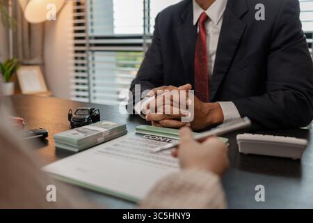 un vendeur de voitures explique les détails d'une voiture et le prix qui intéresse un acheteur, le directeur des ventes de la salle d'exposition a expliqué le montant de int Banque D'Images