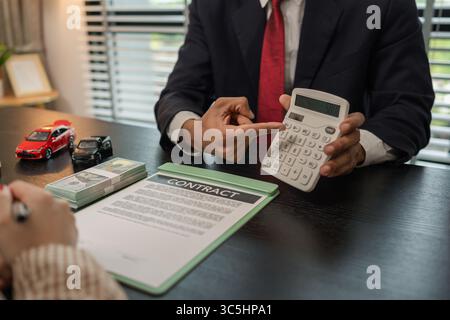 un vendeur de voitures explique les détails d'une voiture et le prix qui intéresse un acheteur, le directeur des ventes de la salle d'exposition a expliqué le montant de int Banque D'Images