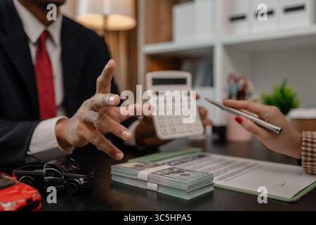 un vendeur de voitures explique les détails d'une voiture et le prix qui intéresse un acheteur, le directeur des ventes de la salle d'exposition a expliqué le montant de int Banque D'Images