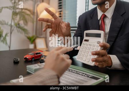 un vendeur de voitures explique les détails d'une voiture et le prix qui intéresse un acheteur, le directeur des ventes de la salle d'exposition a expliqué le montant de int Banque D'Images