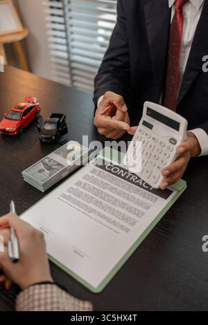 un vendeur de voitures explique les détails d'une voiture et le prix qui intéresse un acheteur, le directeur des ventes de la salle d'exposition a expliqué le montant de int Banque D'Images