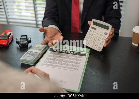 un vendeur de voitures explique les détails d'une voiture et le prix qui intéresse un acheteur, le directeur des ventes de la salle d'exposition a expliqué le montant de int Banque D'Images