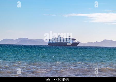 Loreto, basse-Californie du Sud. 11 décembre 2024. Bateau de croisière touristique naviguant sur les eaux calmes de la mer de Cortez, montagnes contre ciel bleu brumeux en b Banque D'Images